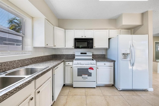 6442 Oak St, Hollywood, FL 33024 - kitchen with white appliances, white cabinets, dark countertops, light tile patterned floors, and a textured ceiling