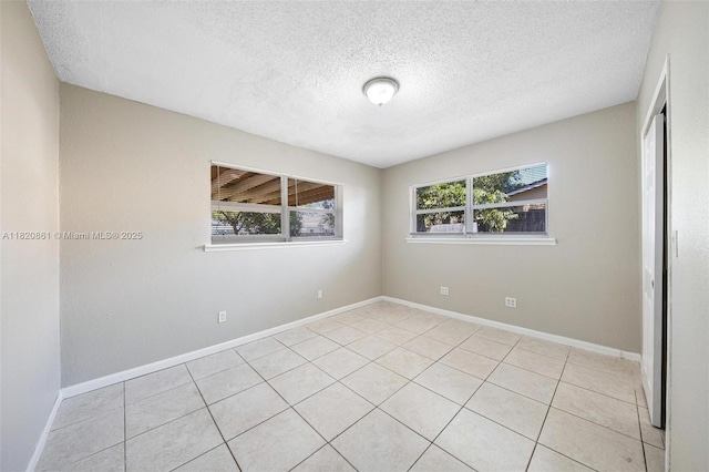 6442 Oak St, Hollywood, FL 33024 - empty room with healthy amount of natural light, a textured ceiling, and light tile patterned floors