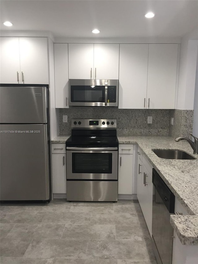 7840 Camino Real Unit P312, Miami, FL 33143 - kitchen with appliances with stainless steel finishes, white cabinets, tasteful backsplash, and recessed lighting