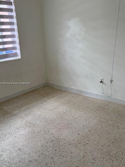 67 NW 34th St, Miami, FL 33127 - empty room with speckle patterned floor and baseboards