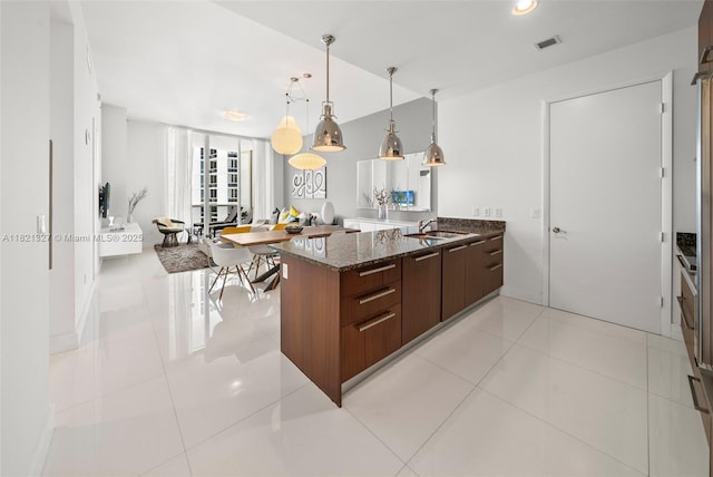 15901 Collins Ave Unit 3302, Sunny Isles Beach, FL 33160 - kitchen featuring modern cabinets, dark stone counters, a peninsula, hanging light fixtures, and light tile patterned flooring