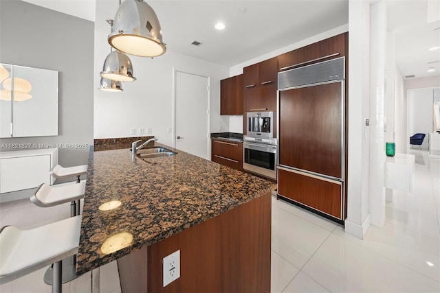 15901 Collins Ave Unit 3302, Sunny Isles Beach, FL 33160 - kitchen with paneled built in refrigerator, a peninsula, light tile patterned floors, dark stone countertops, and modern cabinets