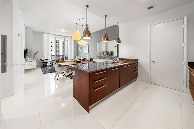 15901 Collins Ave Unit 3302, Sunny Isles Beach, FL 33160 - kitchen featuring a peninsula, dark stone counters, modern cabinets, hanging light fixtures, and light tile patterned flooring