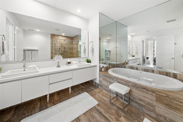 15901 Collins Ave Unit 3302, Sunny Isles Beach, FL 33160 - bathroom with a stall shower, double vanity, wood finished floors, a tub with jets, and recessed lighting