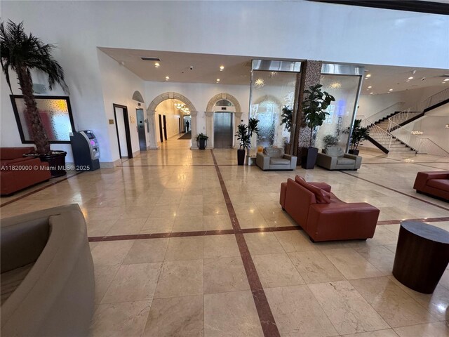 19201 N Collins Ave Unit 826, Sunny Isles Beach, FL 33160 - building lobby featuring a towering ceiling, recessed lighting, and stairs