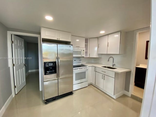345 NE 168th St, North Miami Beach, FL 33162 - kitchen with white appliances, white cabinets, light countertops, recessed lighting, and decorative backsplash