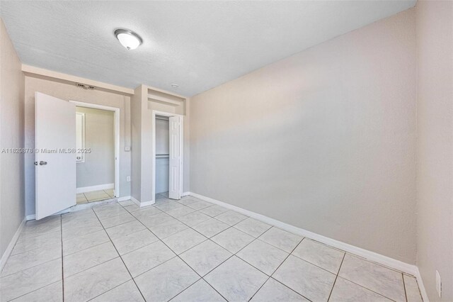 7771 Simms St, Hollywood, FL 33024 - unfurnished bedroom featuring light tile patterned flooring, a closet, and a textured ceiling