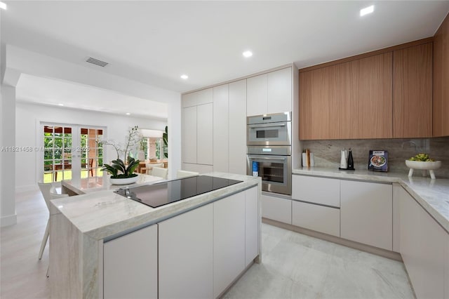 5211 Granada Blvd, Coral Gables, FL 33146 - kitchen with black electric cooktop, stainless steel double oven, modern cabinets, a center island, and recessed lighting
