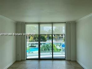 19390 Collins Ave Unit 207, Sunny Isles Beach, FL 33160 - spare room featuring crown molding and a wall of windows