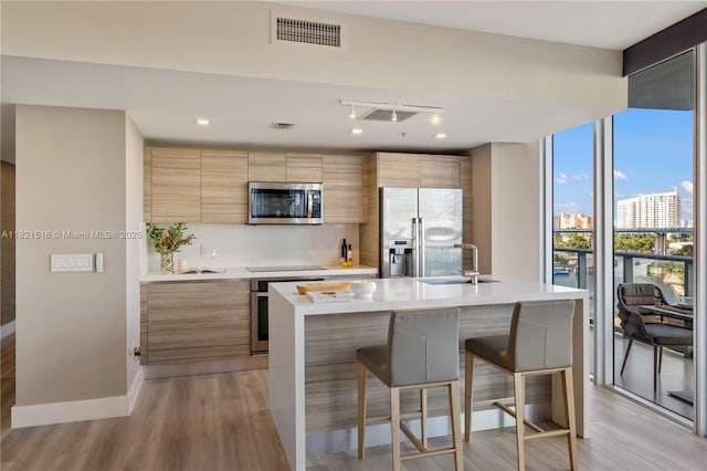 185 SW 7th St Unit 803, Miami, FL 33130 - kitchen featuring appliances with stainless steel finishes, modern cabinets, a kitchen bar, and light countertops