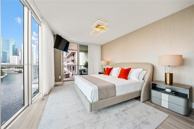 185 SW 7th St Unit 803, Miami, FL 33130 - bedroom with wood finished floors, multiple windows, access to exterior, and floor to ceiling windows