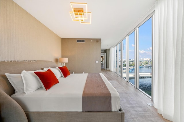 185 SW 7th St Unit 803, Miami, FL 33130 - bedroom featuring a wall of windows, access to exterior, wood finished floors, and a water view