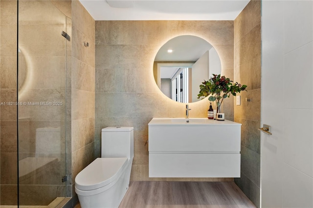 185 SW 7th St Unit 803, Miami, FL 33130 - bathroom with tile walls, vanity, a stall shower, and wood finished floors