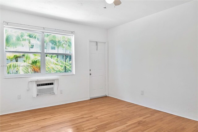 101 Collins Ave Unit 16, Miami Beach, FL 33139 - spare room with a wall mounted air conditioner, light wood-style floors, and a ceiling fan