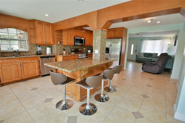 5815 S Farragut Dr, Hollywood, FL 33021 - kitchen with stainless steel appliances, light stone countertops, decorative backsplash, open shelves, and a center island