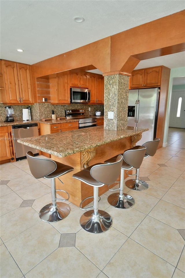 5815 S Farragut Dr, Hollywood, FL 33021 - kitchen with stainless steel appliances, decorative backsplash, a kitchen bar, light stone counters, and recessed lighting