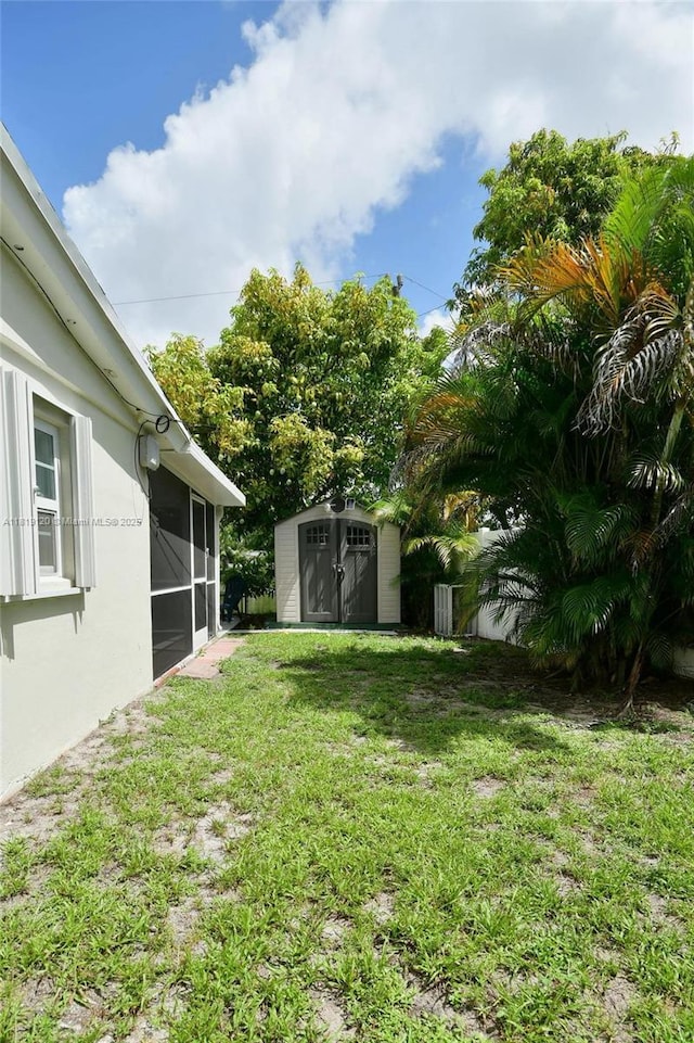 5815 S Farragut Dr, Hollywood, FL 33021 - view of grassy yard with a storage shed and a sunroom