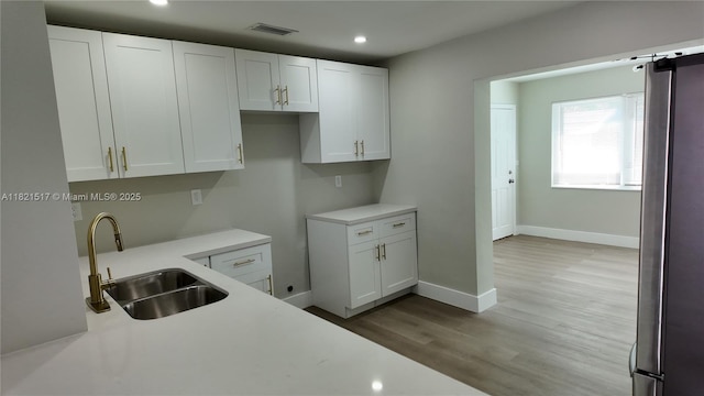 4521 SW 25th Ter, Dania Beach, FL 33312 - kitchen with white cabinets, light countertops, wood finished floors, recessed lighting, and freestanding refrigerator