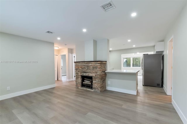 4521 SW 25th Ter, Dania Beach, FL 33312 - unfurnished living room featuring light wood finished floors, recessed lighting, and a stone fireplace