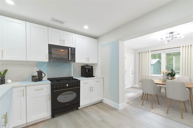 4521 SW 25th Ter, Dania Beach, FL 33312 - kitchen featuring gas stove, black microwave, light wood-style floors, recessed lighting, and white cabinets