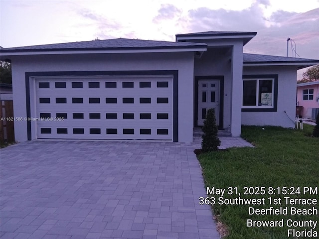363 SW 1st Ter, Deerfield Beach, FL 33441 - prairie-style house featuring stucco siding, decorative driveway, an attached garage, and a front yard