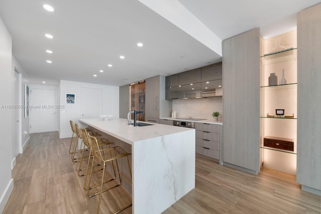 650 NE 32nd St Unit 1904, Miami, FL 33137 - kitchen featuring modern cabinets, gray cabinetry, a kitchen breakfast bar, light wood-type flooring, and recessed lighting