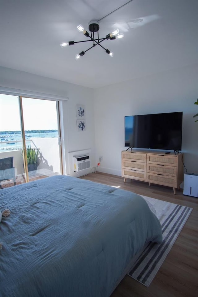 7904 W Dr Unit 501, North Bay Village, FL 33141 - bedroom featuring a chandelier, wood finished floors, access to outside, and a wall mounted AC