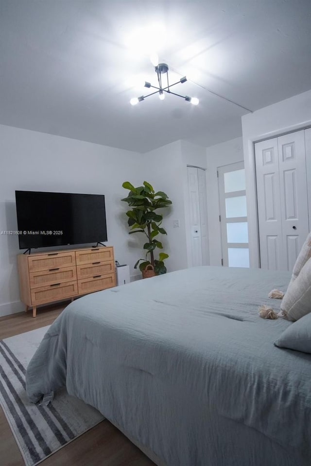 7904 W Dr Unit 501, North Bay Village, FL 33141 - bedroom with a chandelier, wood finished floors, and two closets