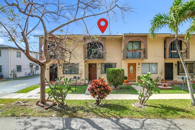 1782 W 42nd St Unit 1782, Hialeah, FL 33012 - view of property with stucco siding, a balcony, and a front yard