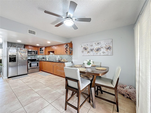 1782 W 42nd St Unit 1782, Hialeah, FL 33012 - kitchen featuring stainless steel appliances, dark countertops, decorative backsplash, ceiling fan, and a textured ceiling