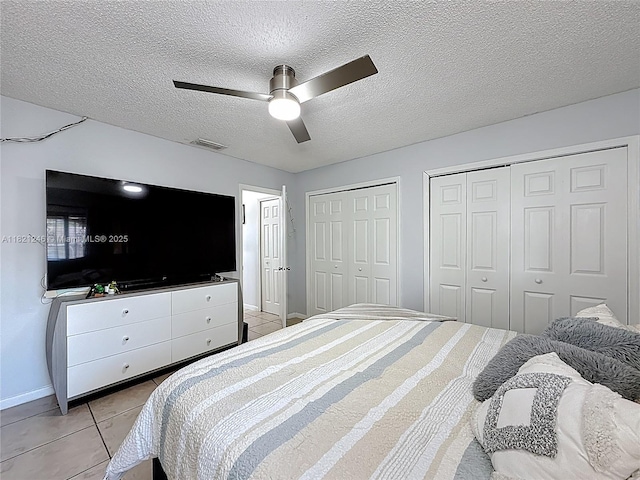 1782 W 42nd St Unit 1782, Hialeah, FL 33012 - bedroom with light tile patterned floors, two closets, a textured ceiling, and a ceiling fan