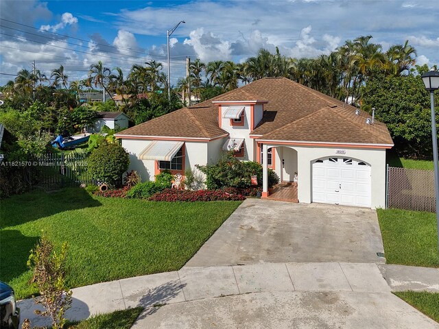 18033 SW 137th Ct, Miami, FL 33177 - view of front of house with stucco siding, an attached garage, roof with shingles, and concrete driveway