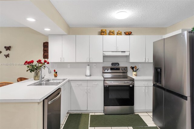 18033 SW 137th Ct, Miami, FL 33177 - kitchen featuring appliances with stainless steel finishes, under cabinet range hood, a peninsula, light countertops, and white cabinets