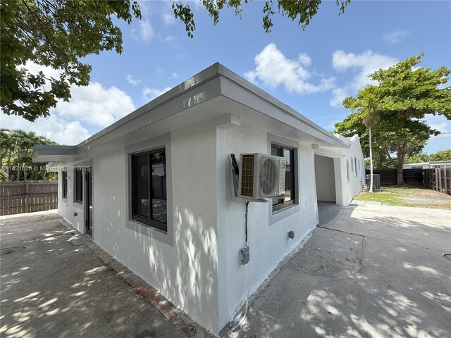 240 SW 55th Ave, Miami, FL 33134 - view of side of home with a patio, stucco siding, and concrete driveway