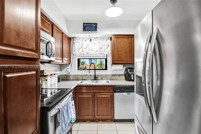 2041 Arcadia Dr, Miramar, FL 33023 - kitchen with appliances with stainless steel finishes, light tile patterned flooring, light countertops, and brown cabinets