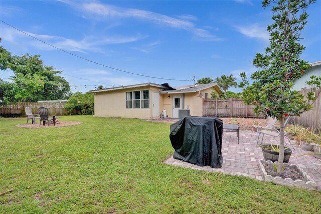2041 Arcadia Dr, Miramar, FL 33023 - back of property featuring stucco siding, a patio, a fenced backyard, and an outdoor fire pit