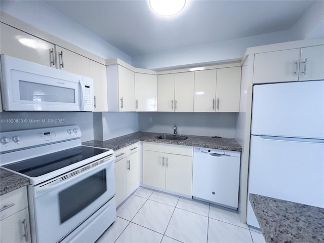 1800 Collins Ave Unit 5C, Miami Beach, FL 33139 - kitchen featuring white appliances, white cabinetry, and dark stone counters