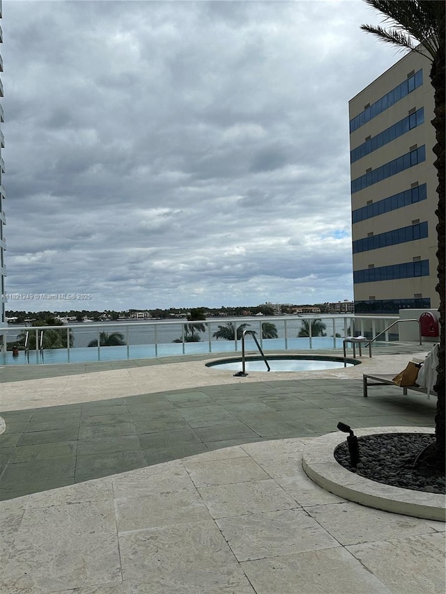 surrounding community featuring a swimming pool, a water view, and a patio