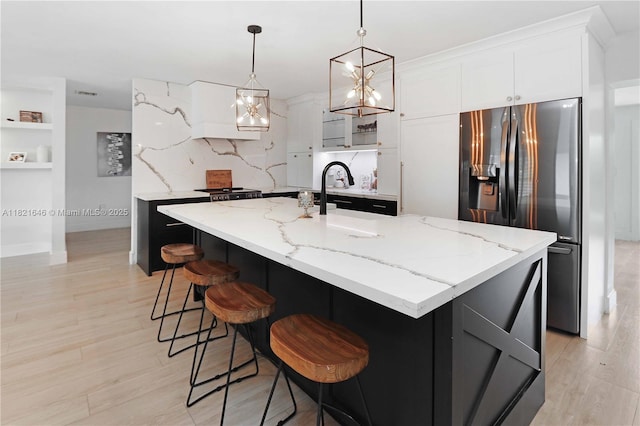 9627 SW 18th Ter, Miami, FL 33165 - kitchen with stainless steel fridge, light stone counters, white cabinetry, and hanging light fixtures