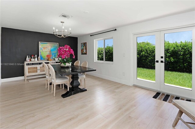 9627 SW 18th Ter, Miami, FL 33165 - dining area with a chandelier, light wood-style flooring, and an accent wall