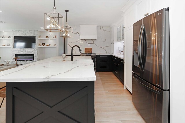 9627 SW 18th Ter, Miami, FL 33165 - kitchen with stainless steel appliances, white cabinets, light wood-style floors, open floor plan, and light stone counters