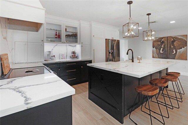 9627 SW 18th Ter, Miami, FL 33165 - kitchen with stainless steel range, dark cabinetry, a kitchen island with sink, hanging light fixtures, and recessed lighting