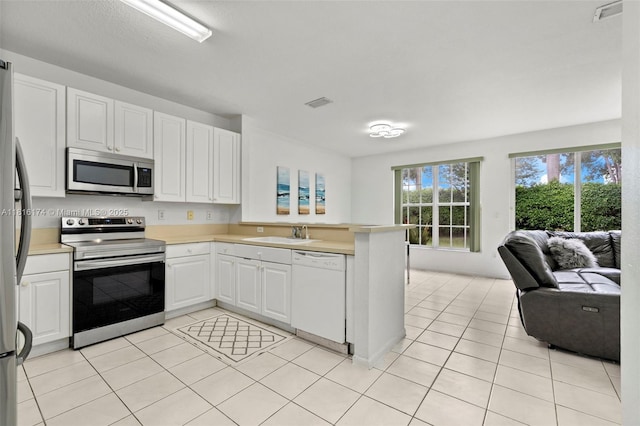 1968 NW 79th Way, Pembroke Pines, FL 33024 - kitchen with appliances with stainless steel finishes, open floor plan, a peninsula, and light tile patterned floors