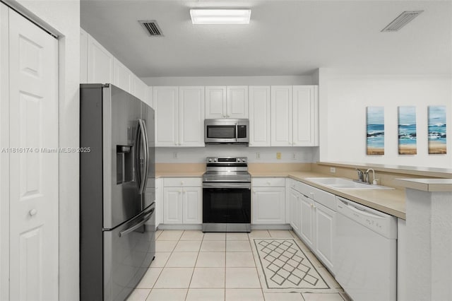 1968 NW 79th Way, Pembroke Pines, FL 33024 - kitchen featuring appliances with stainless steel finishes, light tile patterned floors, light countertops, white cabinetry, and a peninsula