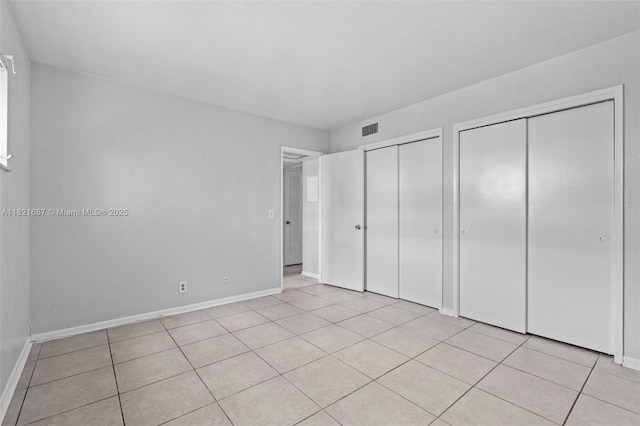220 Croton Ave Unit 102, Lantana, FL 33462 - unfurnished bedroom featuring two closets and light tile patterned flooring