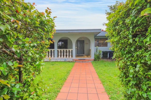 5959 SW 16th Ter, West Miami, FL 33155 - view of exterior entry featuring stucco siding, covered porch, and a lawn