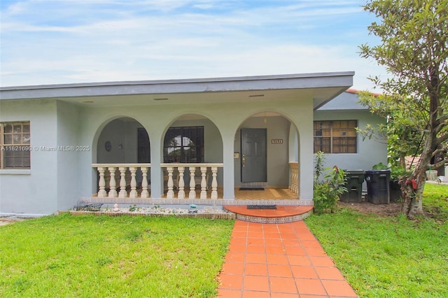 5959 SW 16th Ter, West Miami, FL 33155 - property entrance with stucco siding, a porch, and a yard