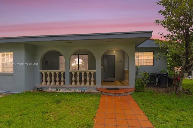 5959 SW 16th Ter, West Miami, FL 33155 - doorway to property with stucco siding, covered porch, and a yard