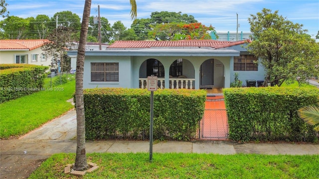 5959 SW 16th Ter, West Miami, FL 33155 - mediterranean / spanish house featuring a porch, a fenced front yard, a gate, and stucco siding