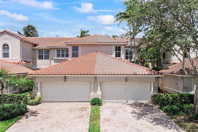 1382 Harbor Vw W, Hollywood, FL 33019 - mediterranean / spanish-style home featuring decorative driveway, stucco siding, an attached garage, and a tiled roof